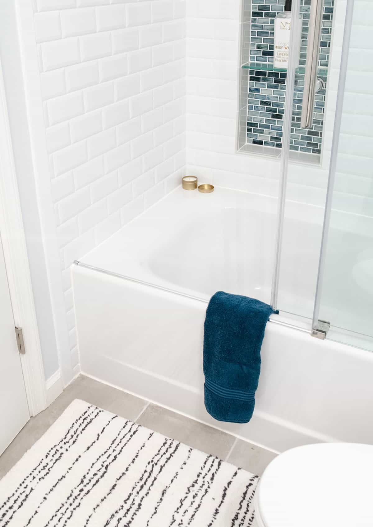 American Standard Cambridge Alcove Bathtub with sliding glass door and tiled shower inlay wall.
