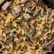 Top down view of beef stroganoff with noodles in a skillet.