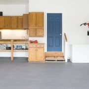 Garage with gray painted floor that is clean and organized.