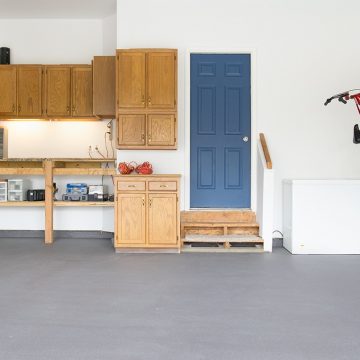 Garage with gray painted floor that is clean and organized.
