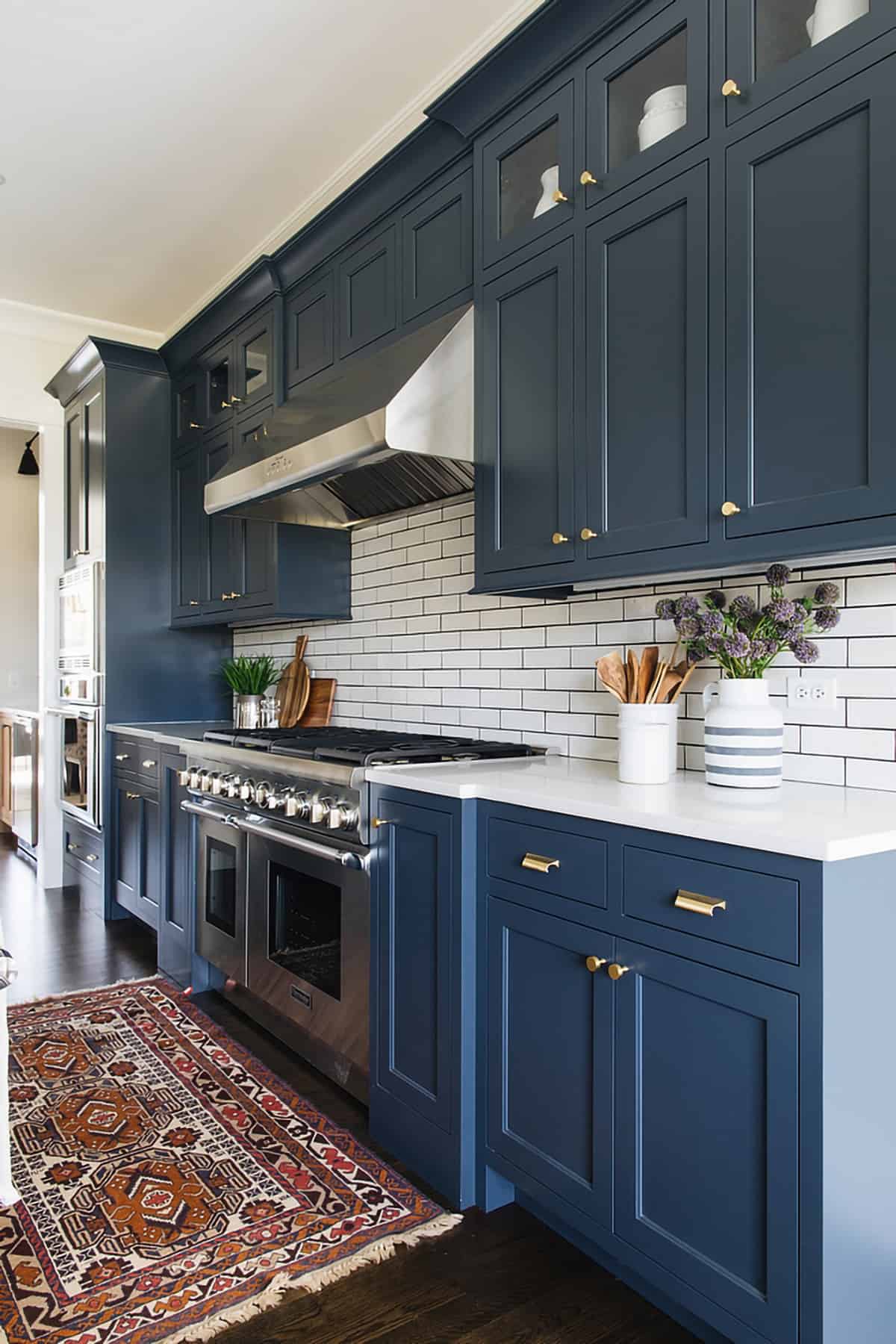 Modern traditional kitchen featuring Benjamin Moore Blue Note cabinets and white subway tiles with black grout on backsplash.