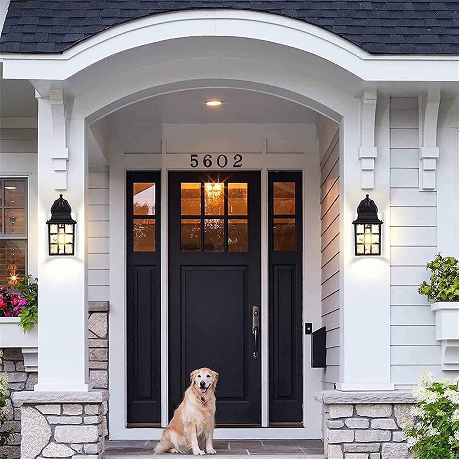 Black and white front porch with black doors and large lanterns.