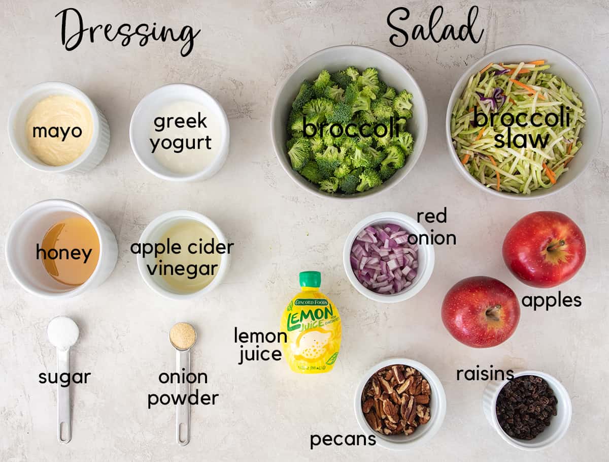 Broccoli apple salad ingredients laid on a table with text labels.