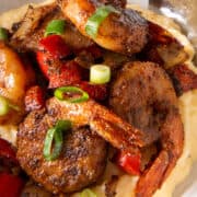 Closeup of a pile of seasoned shrimp over top of cheese grits.