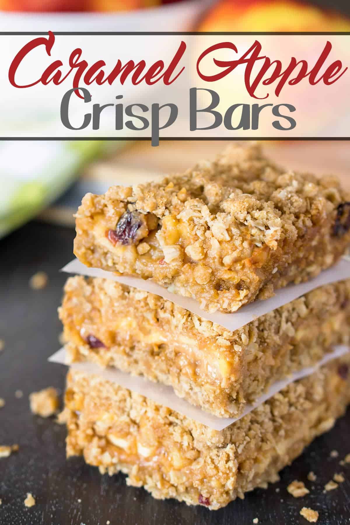 Caramel Apple Bars stacked on parchment paper freshly baked from the oven with post title.