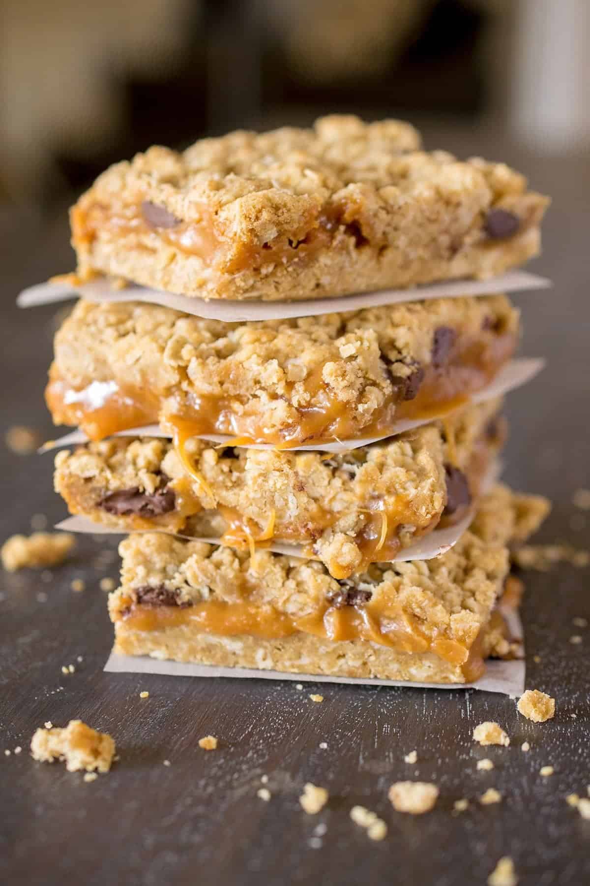 Caramelitas with oatmeal, chocolate chips, and caramel freshly baked and stacked on parchement paper.