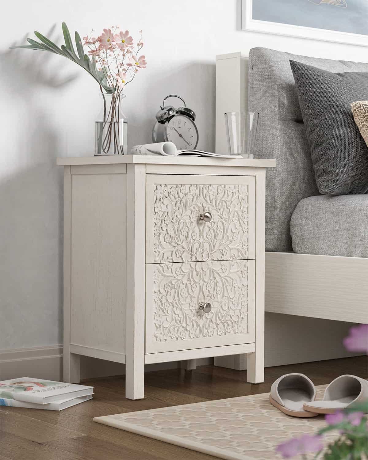 White french country nightstand with a floral motif on the two drawers.