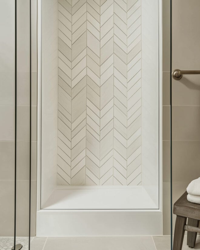 Beige shower with creative mismatched size chevron pattern tiles.