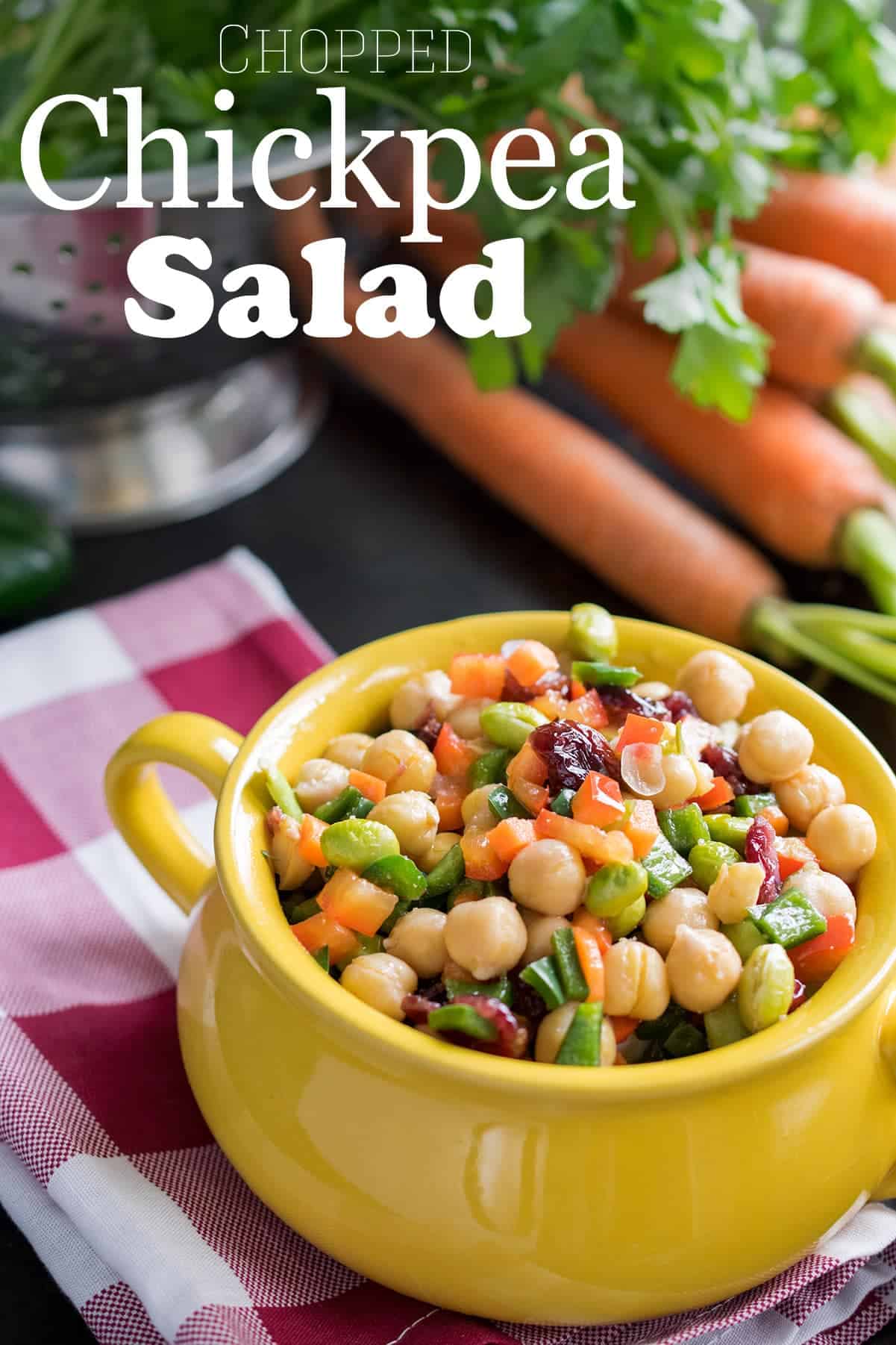 Chickpea Salad in yellow bowl with diced fresh veggies, cranberries, chickpeas, & vinaigrette dressing.