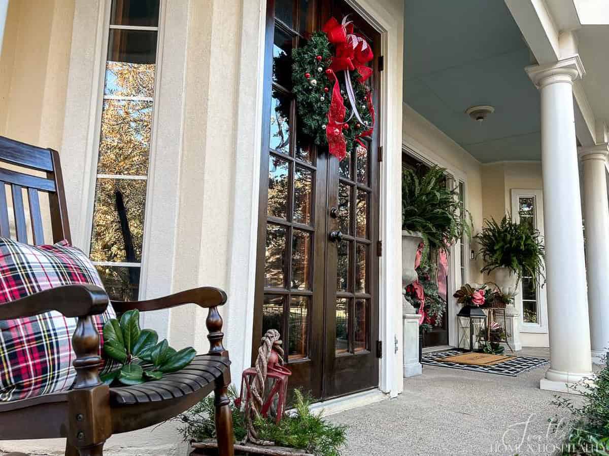 Southern Christmas Veranda with columns and rocking chairs decorated with plaid pillows.