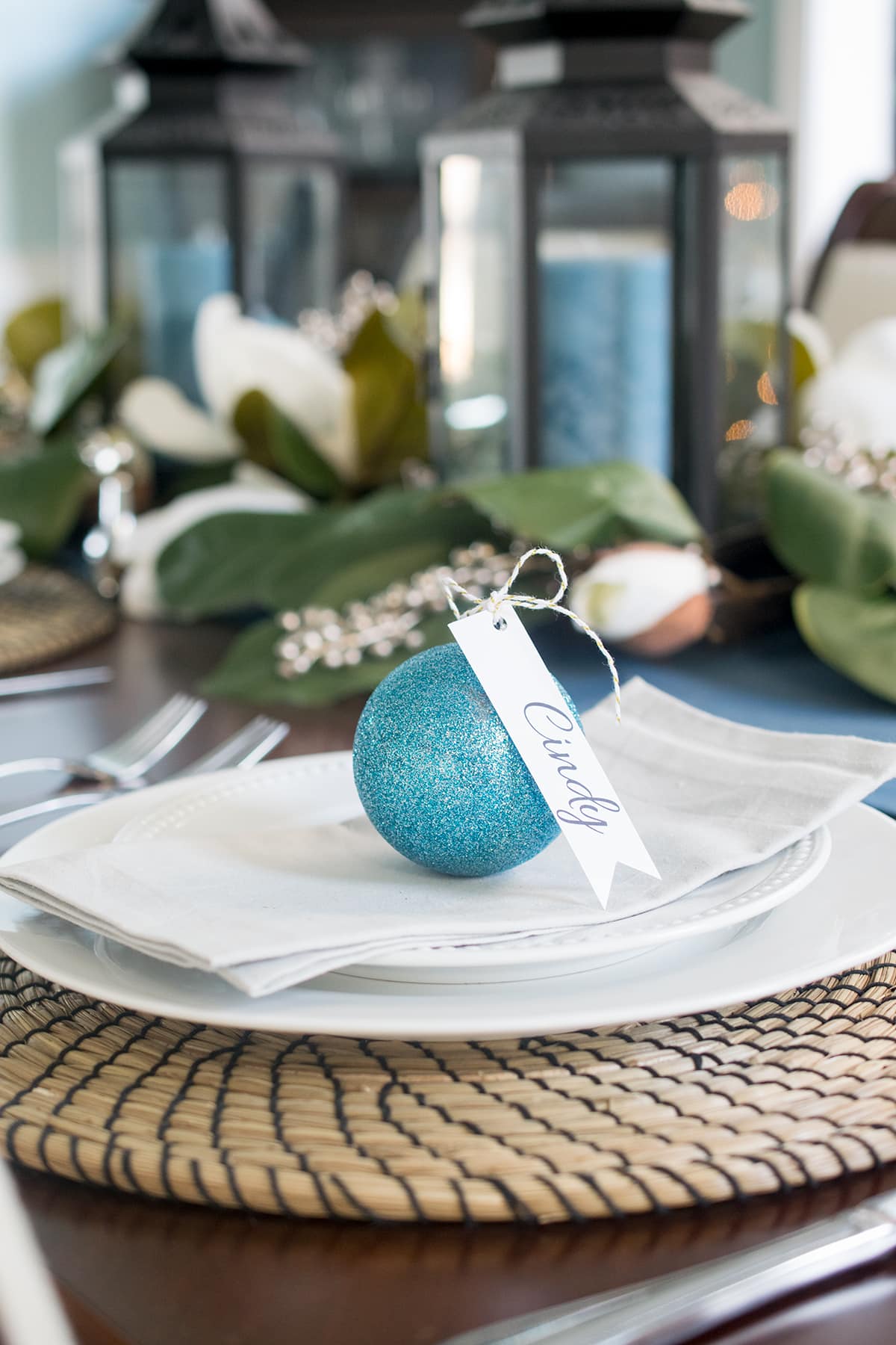 Christmas party seating arrangement idea with sparkly personalized ornament atop dinnerware.