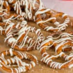 Cinnamon sugar pretzels with white chocolate drizzle on brown paper.