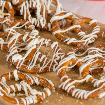 Cinnamon sugar pretzels with white chocolate drizzle on brown paper.