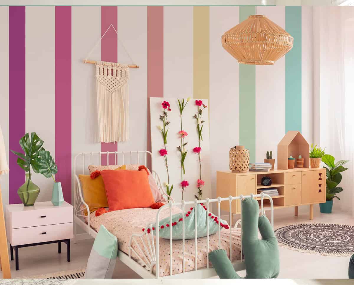 Colorful rainbow style stripes on girl's bedroom wall with coordinating-colored accessories.