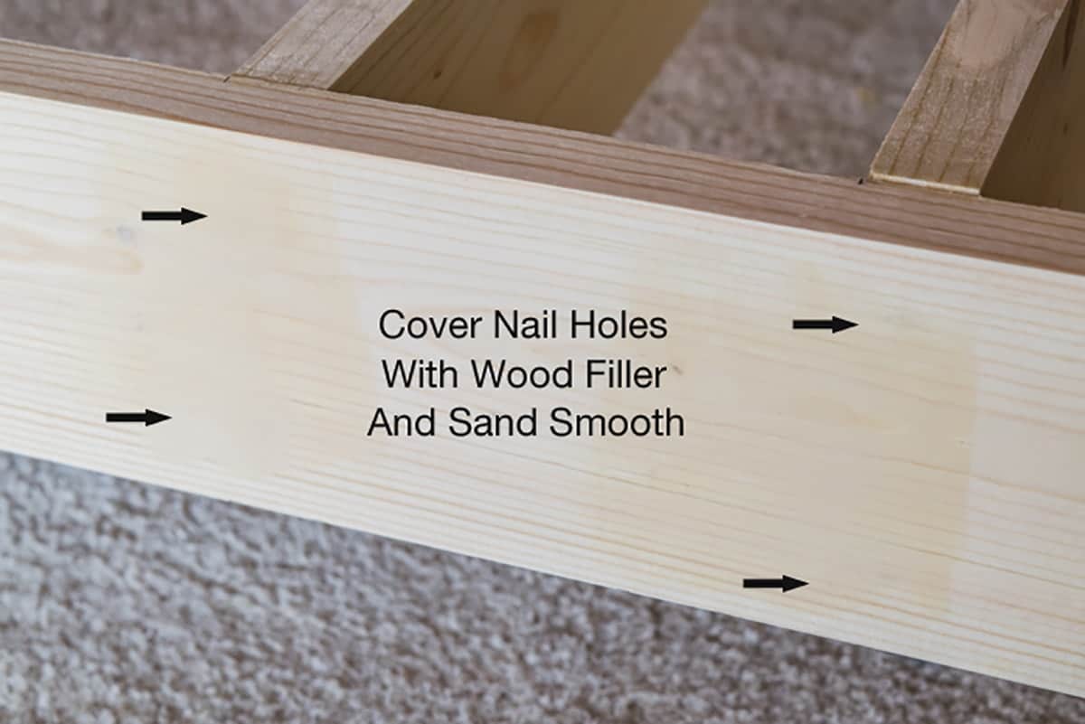 Frame of unpainted wall shelf with wood filler applied and sanded over nail holes.