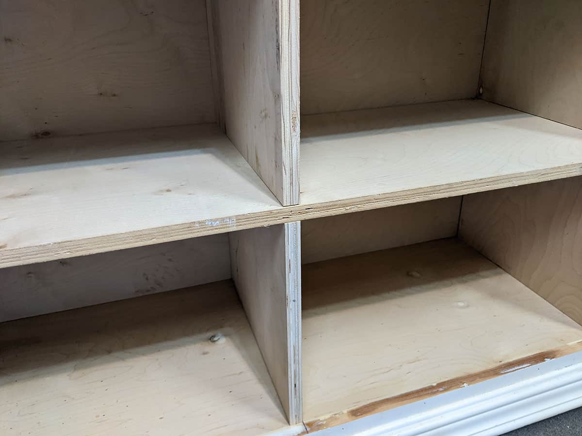 Plywood shelves being added to the interior of a dresser to make cubbies.