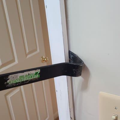 Crowbar removing door casing.