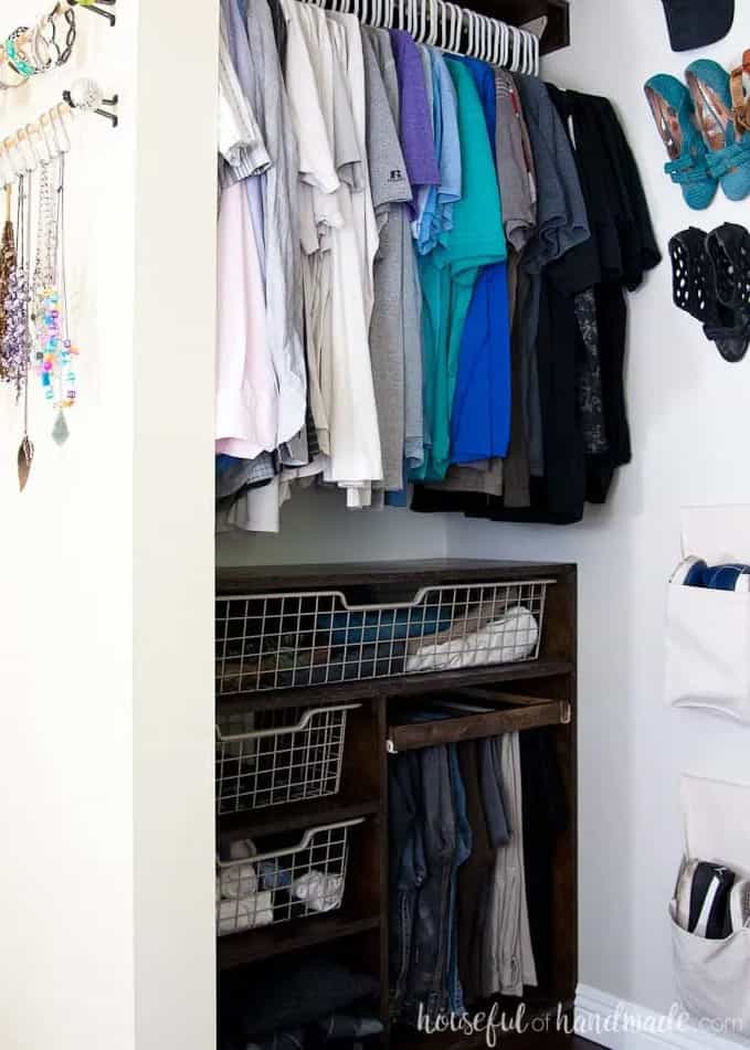 A white small closet with a small custom built plywood drawers and baskets.