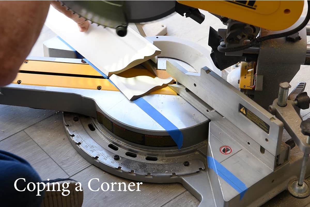 A miter cut being made in crown molding in preparation of coping.