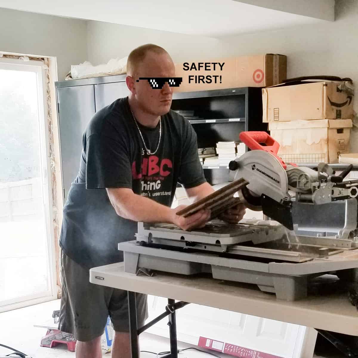 Man cutting tile with a sliding tile saw.
