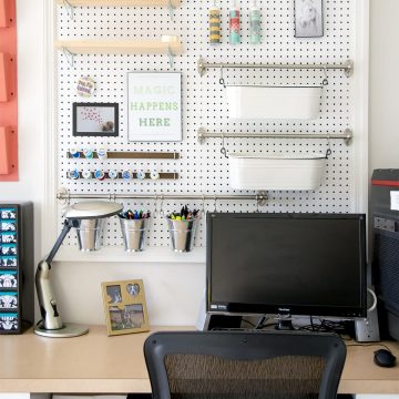 Desk area with large pegboard for craft and office supplies.
