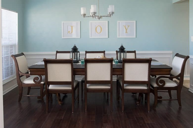 Dining room before makeover. Dark wood floors with dark 8 person dining table and soft blue wall color 