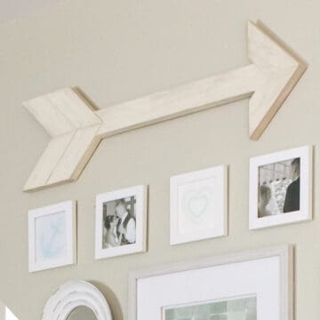 DIY arrow wall decor hanging in a gallery wall,