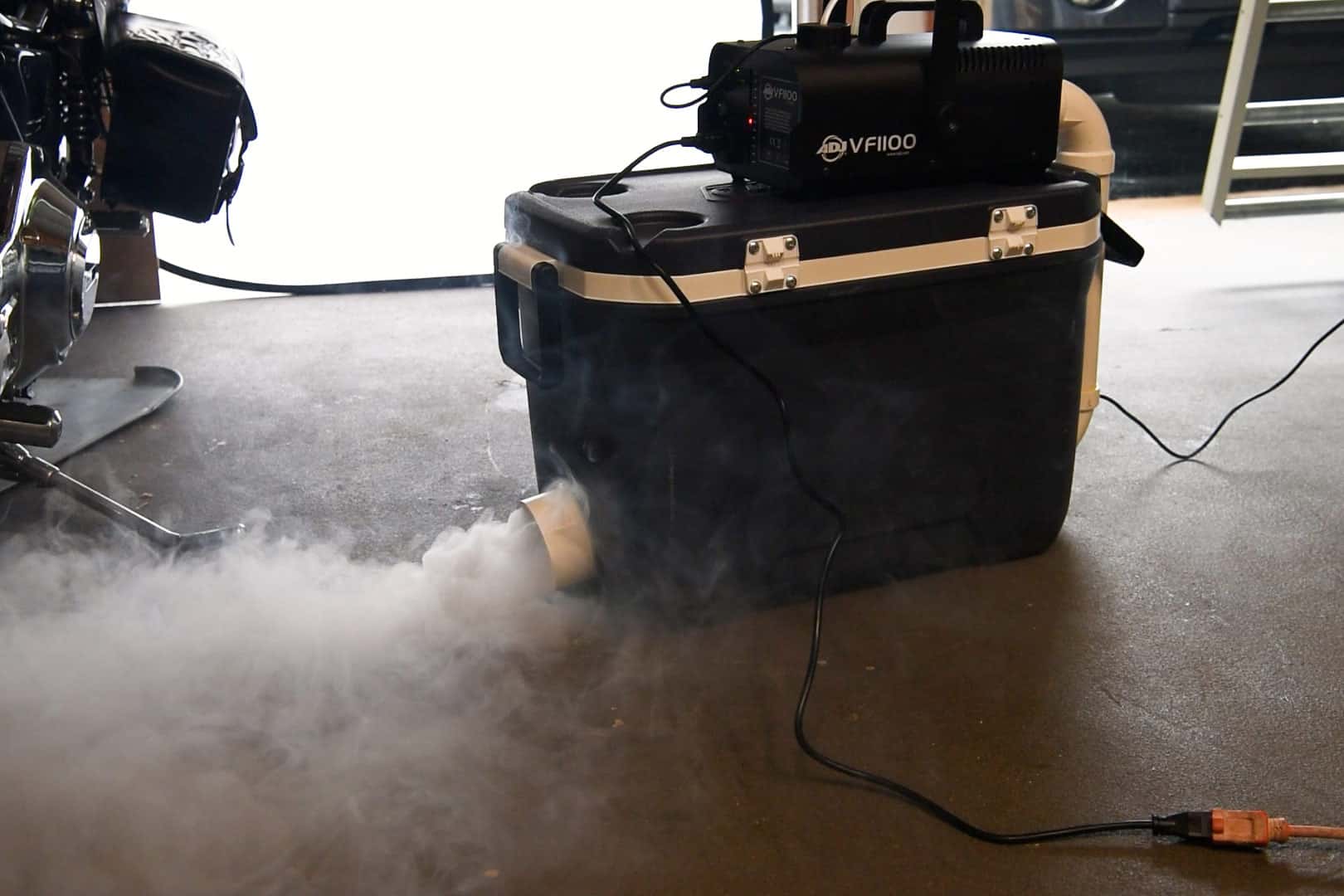 A working fog machine with low lying fog coming out the front.