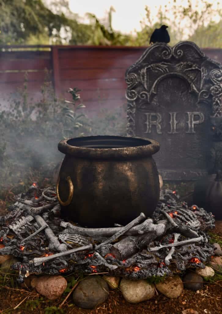 A witch's cauldron over a faux fire made of bones.