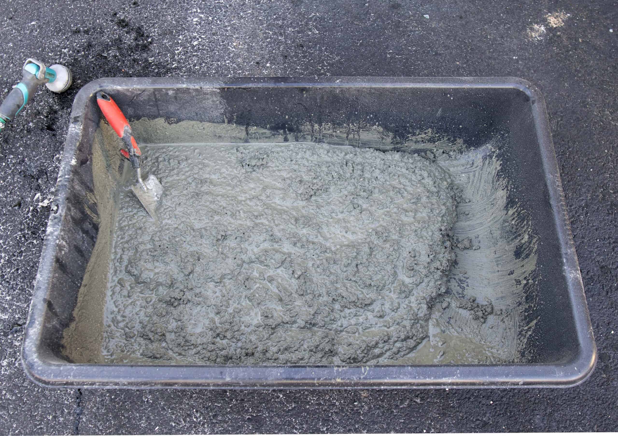 Mixed concrete with water in a trough with thick oatmeal consistency