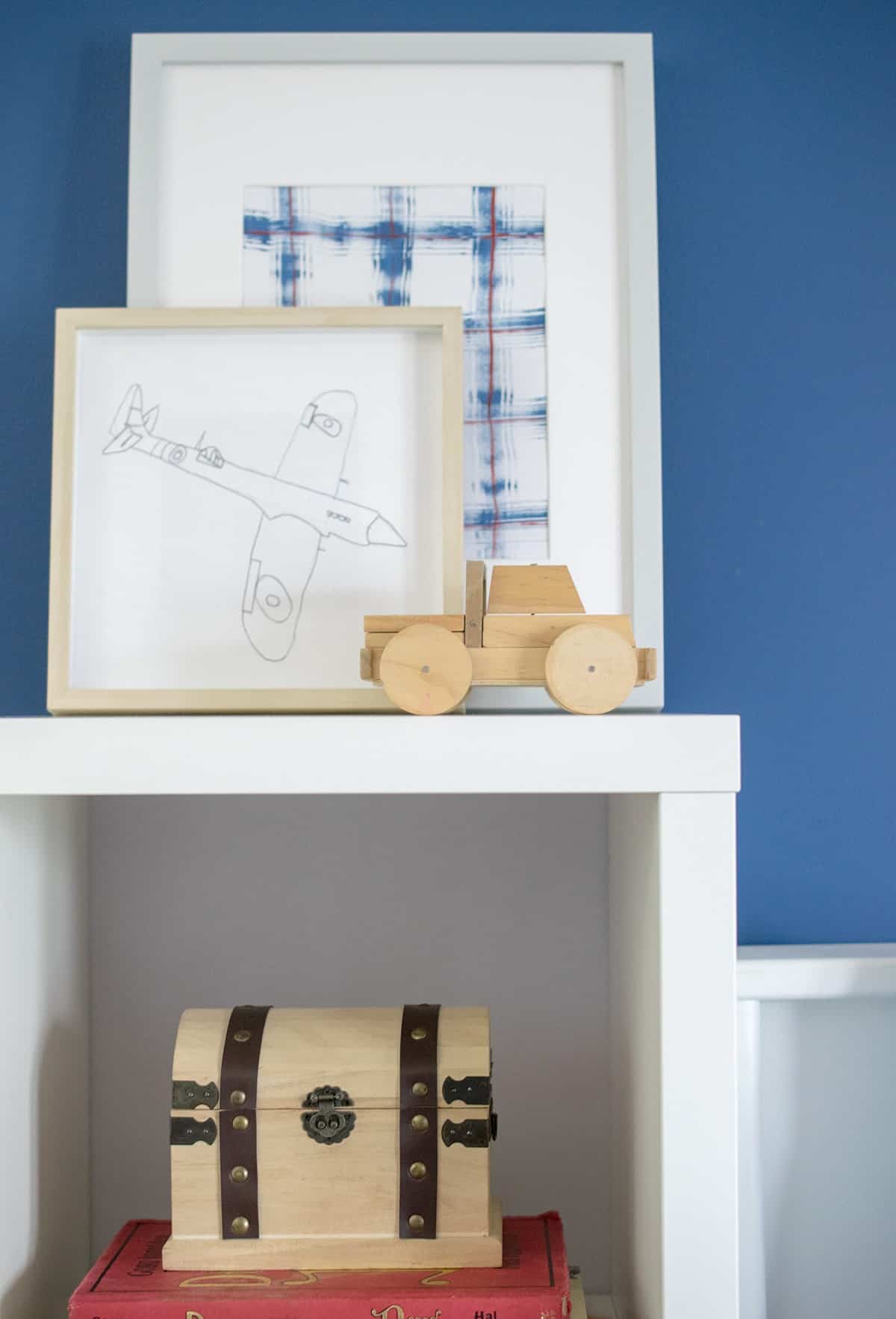 Child's original artwork display on white shelf bedside shelf