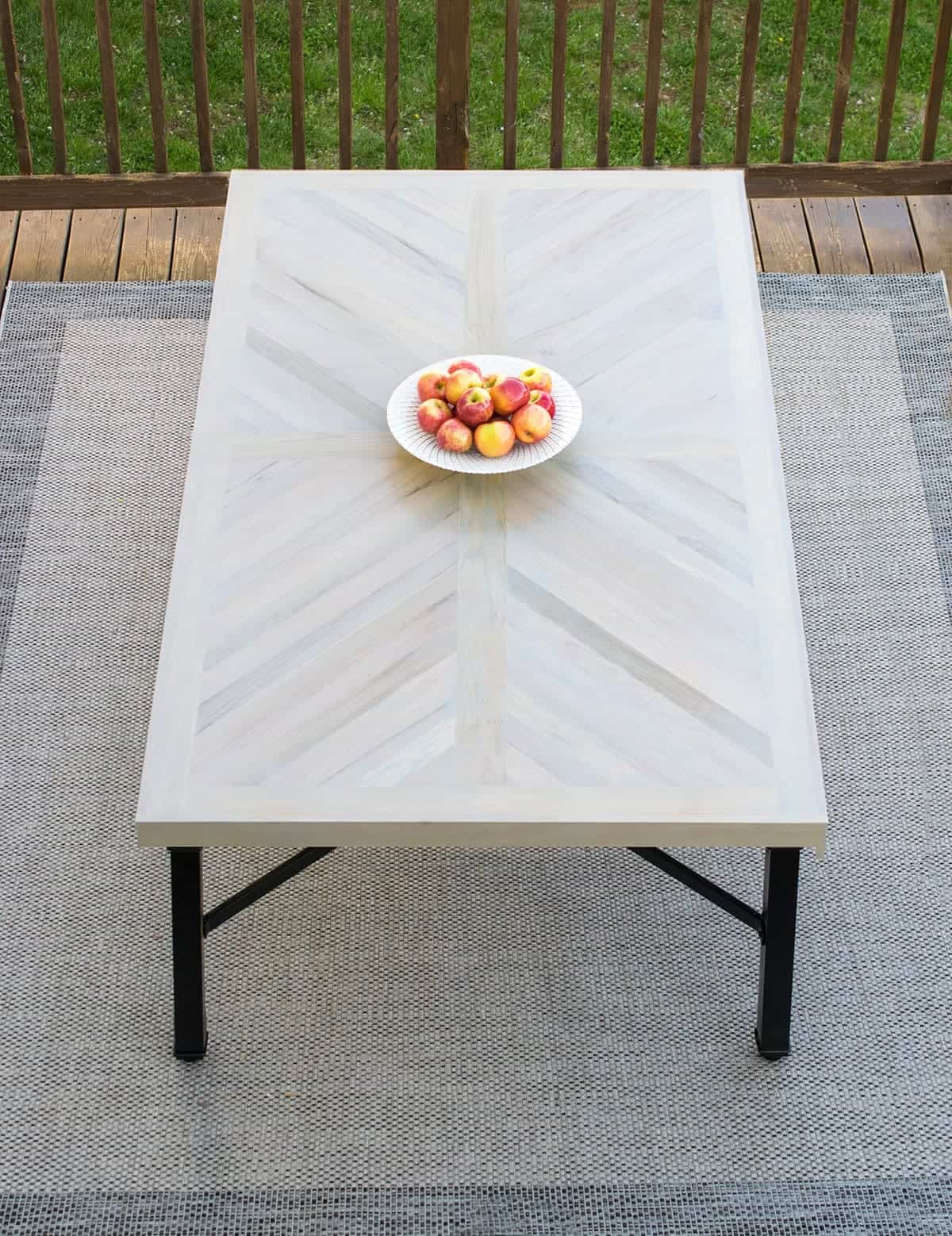 Wood farmhouse table in X cross or herringbone pattern with black legs.