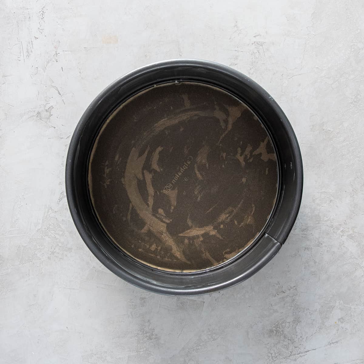 A springform pan lined with parchment paper.