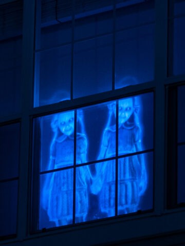 Spooky ghosts in the window for Halloween holographic window decorations.