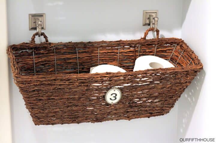 Wicker window garden box hanging on wall to use as bathroom toiletry storage.