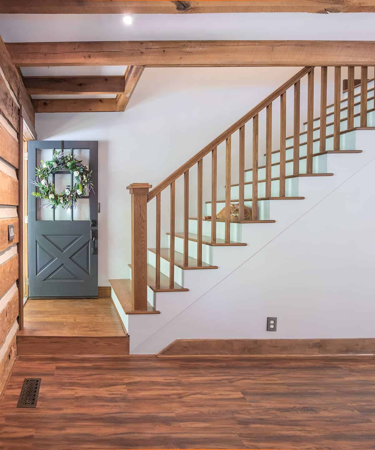 Beautiful craftsman style staircase with wood banister and treads on white stringer and wall.