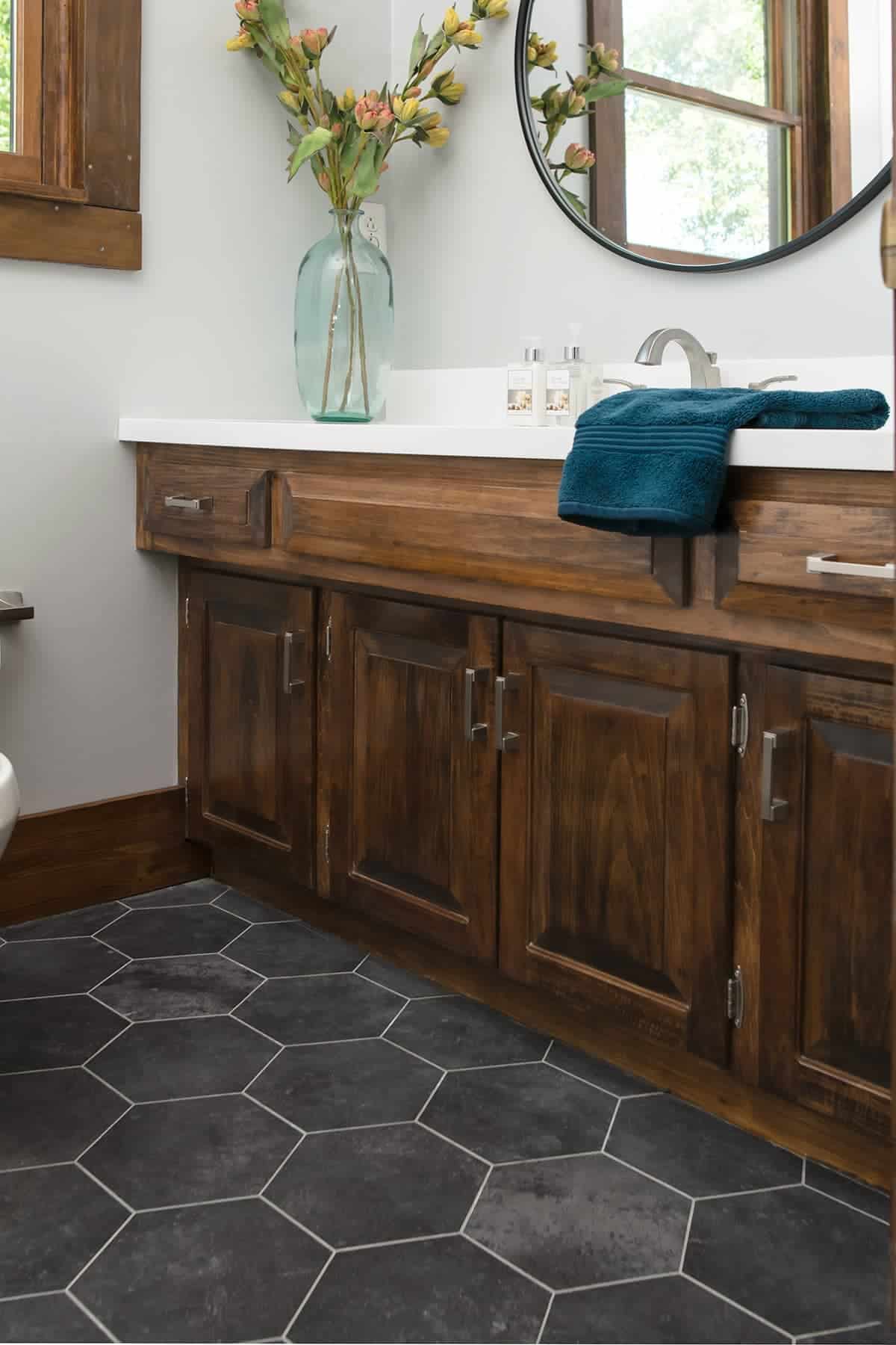 Wood Vanity and Black hexagon floor in modern rustic bathroom.