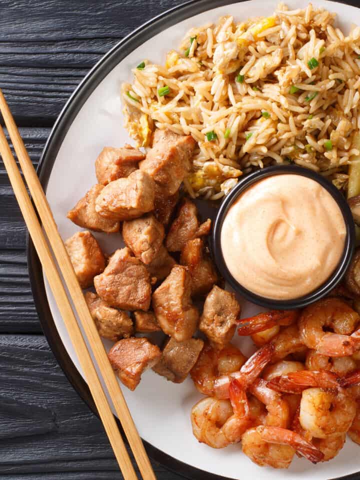 Hibachi Chicken and Shrimp on a plate with yum yum sauce in the center.