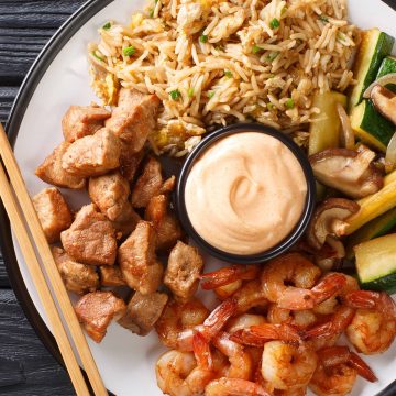 Hibachi Chicken and Shrimp on a plate with yum yum sauce in the center.