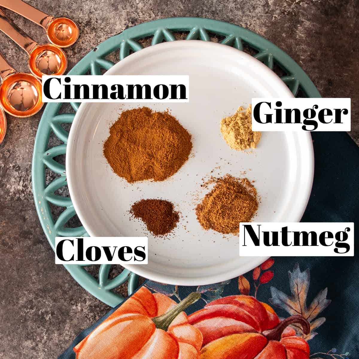 Ingredients to make homemade pumpkin spice mixture poured out onto a plate.