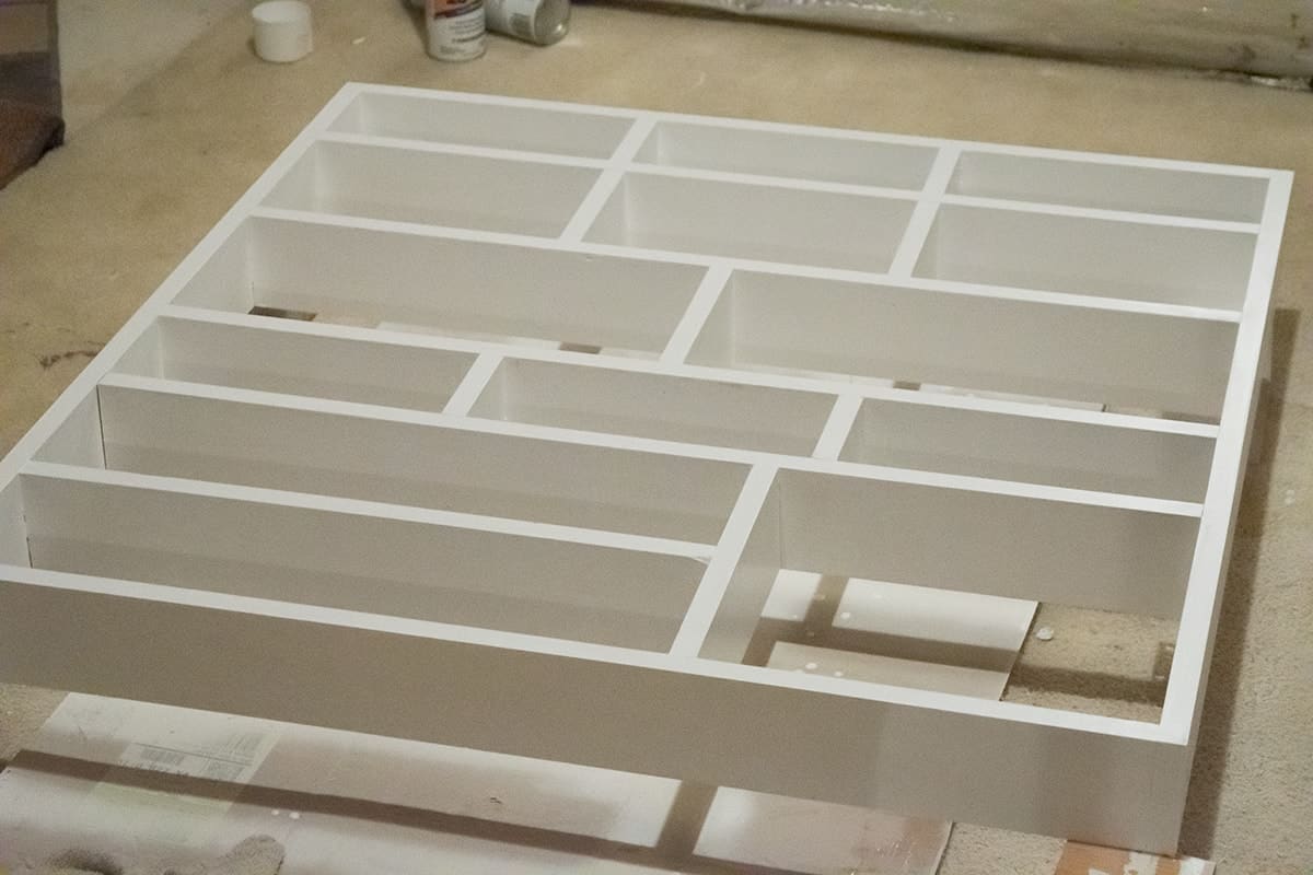 DIY wall shelf with fresh coat of white paint positioned horizontally.