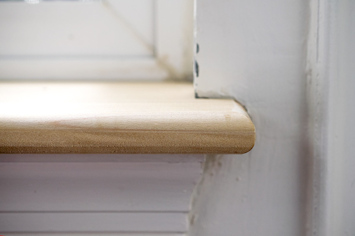 Closeup of the bullnose end of a window sill overlapping the wall.
