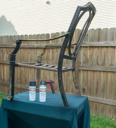 A metal chair on a table prepped for spray painting.