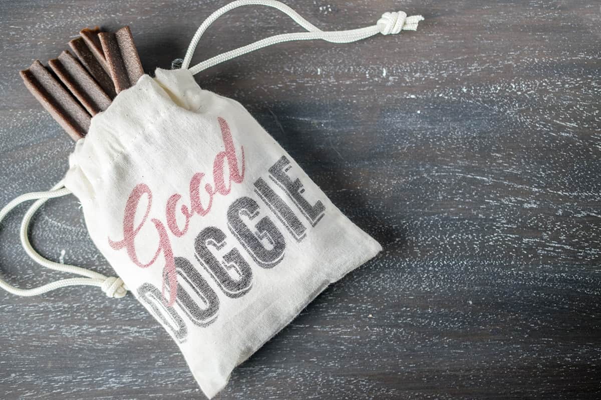 Small cinched pouch filled with treats. It reads Good doggie on the front of the pouch.