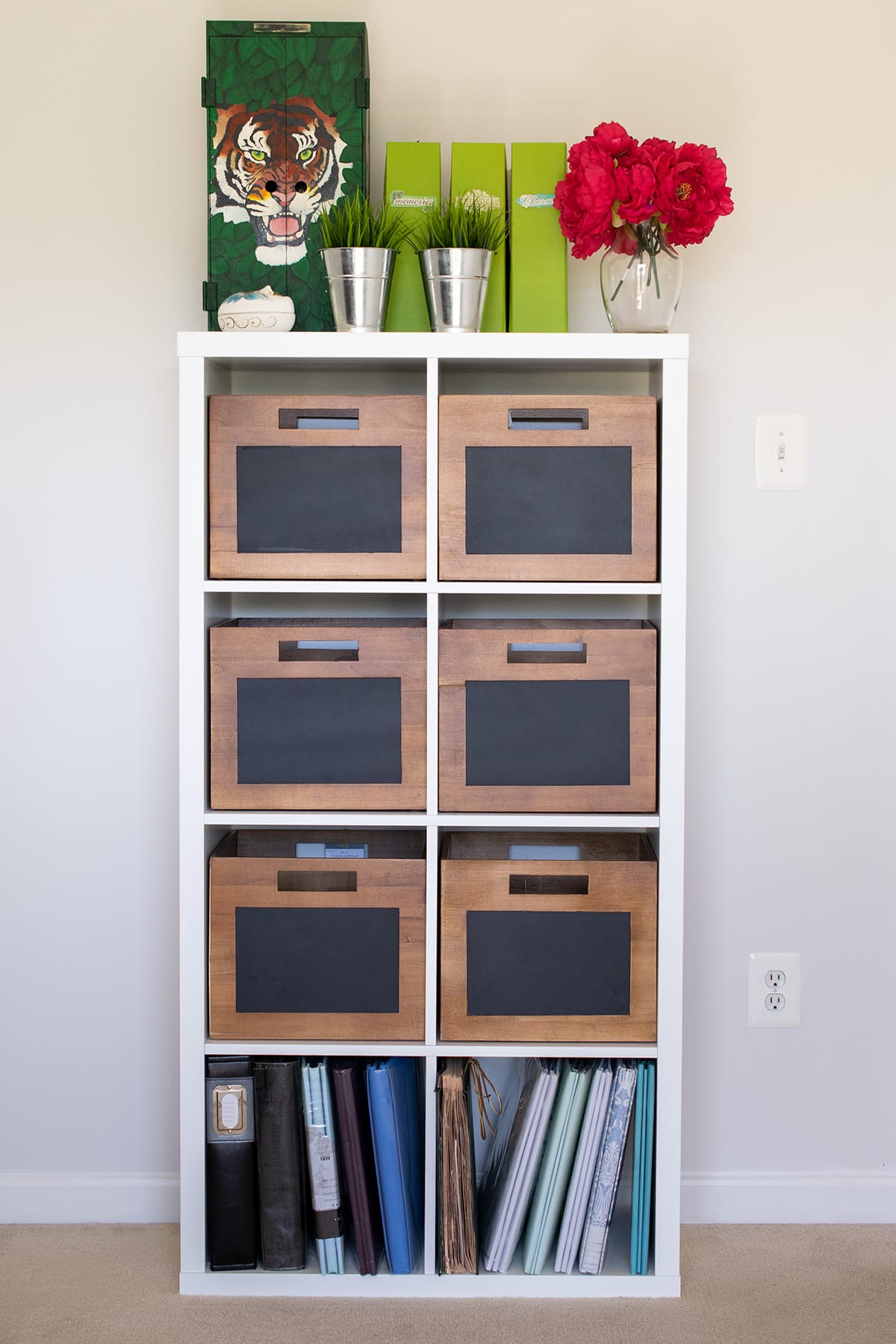 Ikea Kallax organization idea with wood storage bins with chalkboard fronts, topped with potted plants and binders.