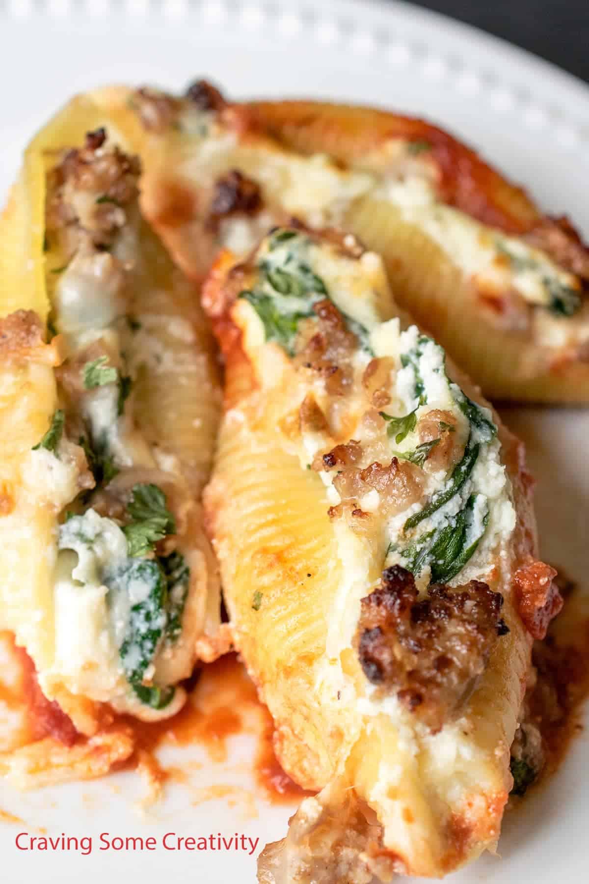 Plated Close up of stuffed shells with spinach, ricotta, and Italian sausage after baking