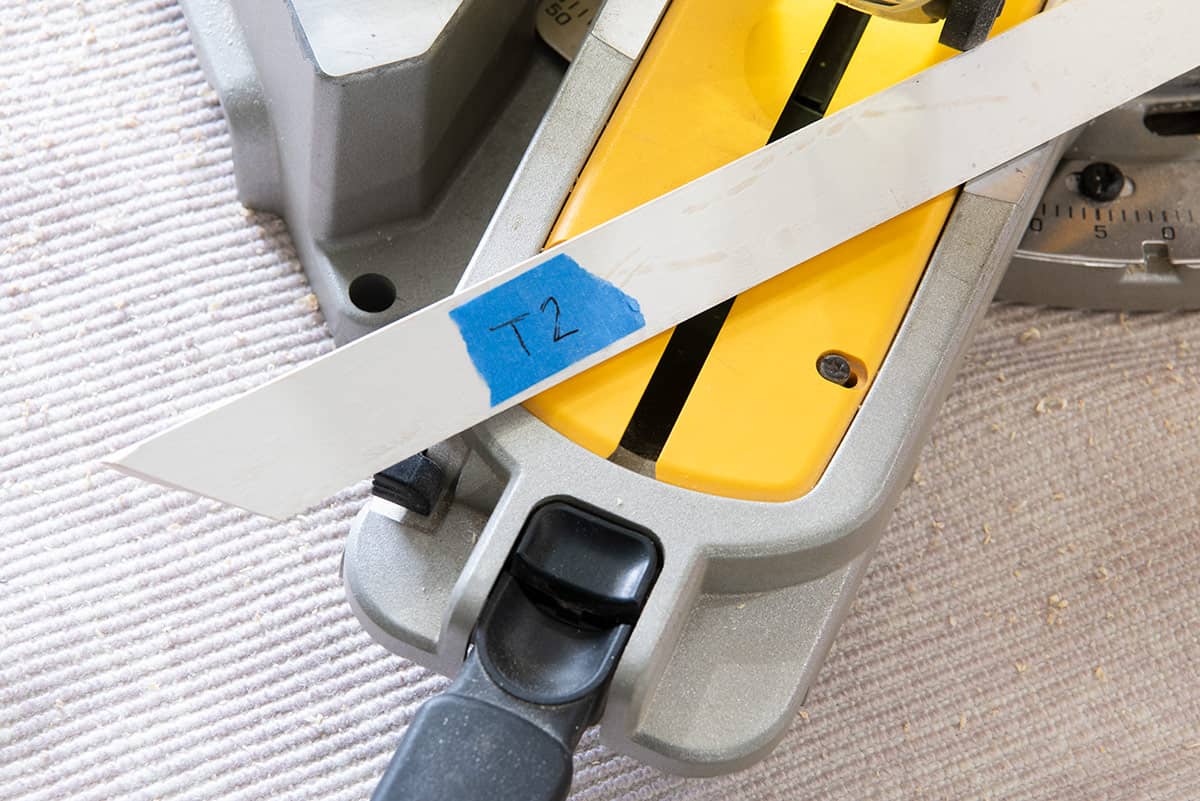 Closeup of a painter's tape label on the back of a piece of wood trim.