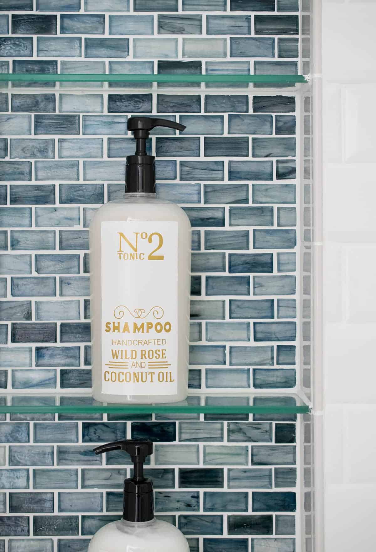 Blue glass mosaic tile shower inlet with glass shelves