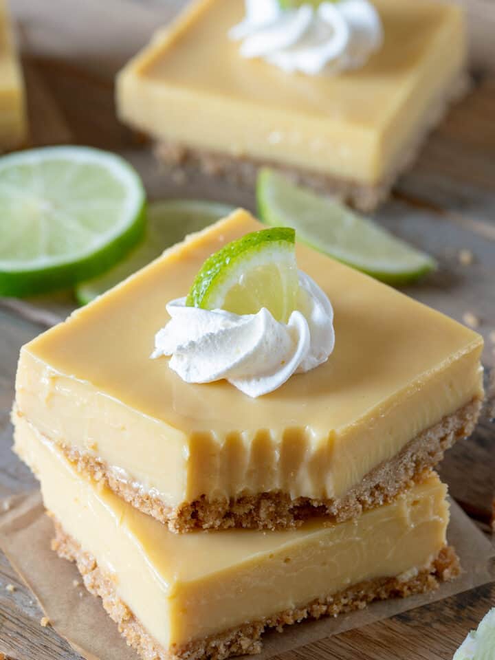 Two stacked key lime bars with a fork bite taken out of the top bar.