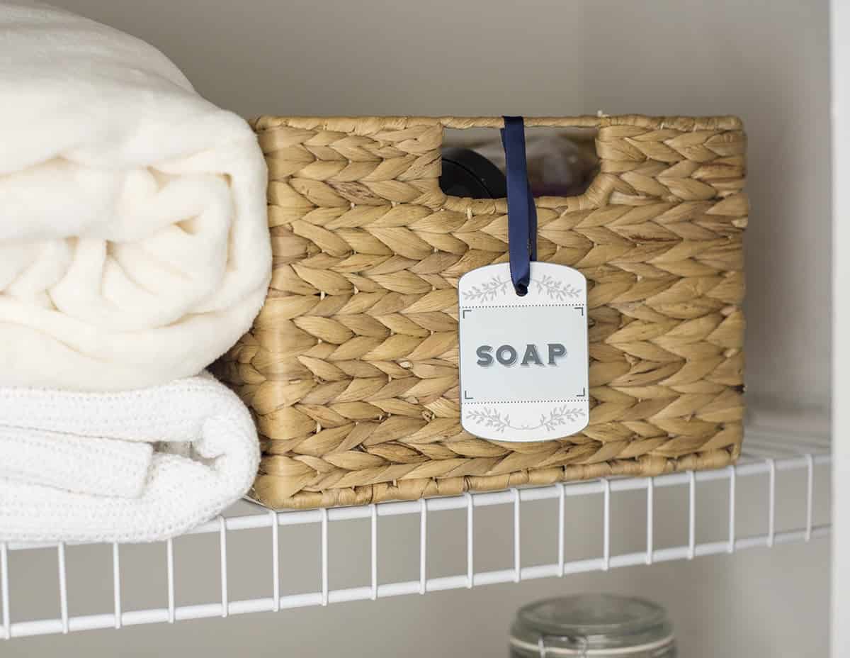 A label for soap on a hyacinth basket in an organized linen closet.